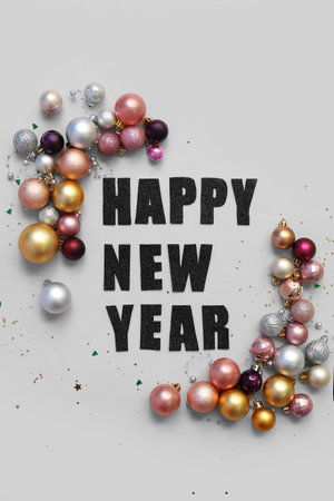 Text HAPPY NEW YEAR with Christmas balls and confetti on blue backgroundの写真素材