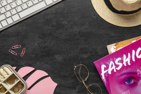 Frame made of female accessories, keyboard and magazines on dark backgroundの写真素材