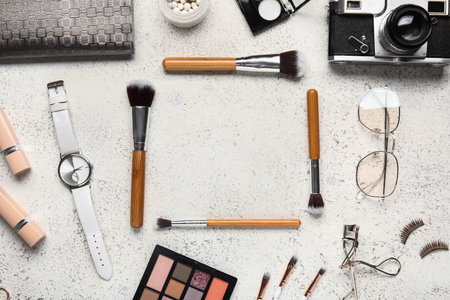 Frame made of makeup brushes, cosmetics and accessories on light backgroundの写真素材