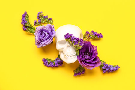 Human skull with beautiful eustoma flowers on yellow backgroundの写真素材