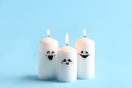 Different burning candles for Halloween celebration on blue backgroundの写真素材