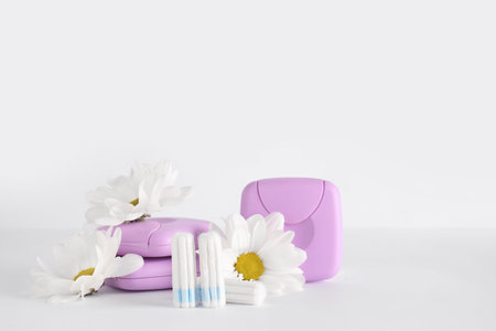 Menstrual tampons, storage boxes and chamomile flowers on white backgroundの写真素材