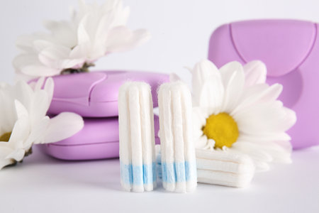 Menstrual tampons, storage boxes and chamomile flowers on white background, closeupの写真素材
