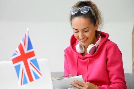 Mature woman with laptop studying English online at homeの写真素材