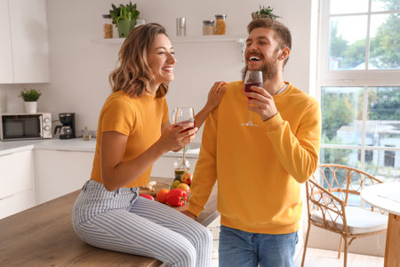 Happy couple in love drinking wine in kitchenの写真素材