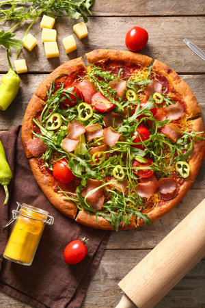 Delicious pizza with tomatoes and arugula on wooden backgroundの写真素材