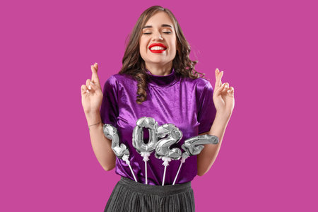 Young woman with figure 2024 crossing fingers on purple background. New Year celebration