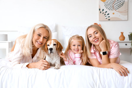 Happy family with cute dog in bedroomの写真素材