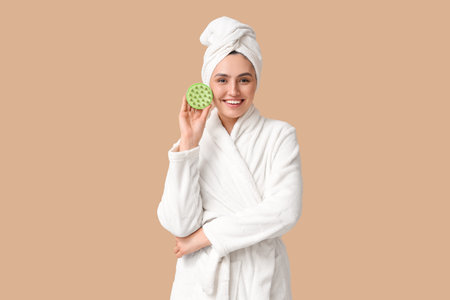 Happy young woman with hair scalp massager on brown backgroundの写真素材