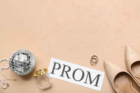 Word PROM with female shoes, disco ball and perfume bottle on beige grunge backgroundの写真素材