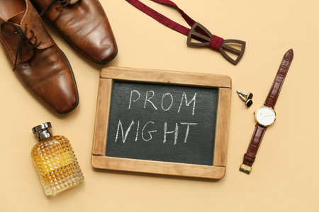 Chalkboard with text PROM NIGHT, male shoes and wristwatch on beige backgroundの写真素材