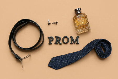 Word PROM with tie, belt and perfume bottle on beige backgroundの写真素材