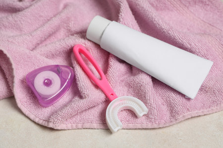 Towel with children's toothbrush, toothpaste and dental floss on grunge backgroundの写真素材