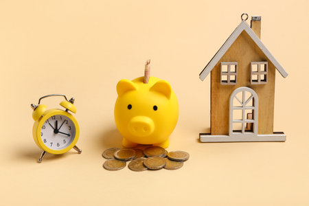 Composition with piggy bank, alarm clock and house figure. Time management conceptの写真素材