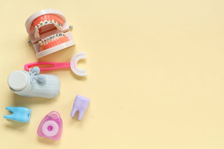 Children's toothbrush with jaw model and dental floss on beige backgroundの写真素材