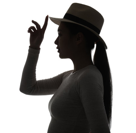 Silhouette of young Asian woman in hat on white backgroundの写真素材