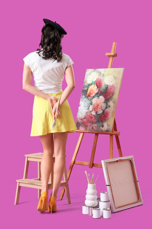 Young pin-up artist with picture and cans on color background, back viewの写真素材