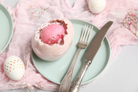 Stylish festive table setting for Easter celebration with eggs on white background