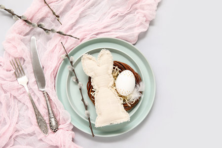 Stylish festive table setting for Easter celebration with nest on white background