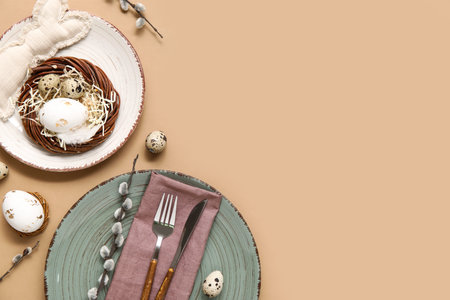 Stylish festive table setting for Easter celebration with nest on beige background
