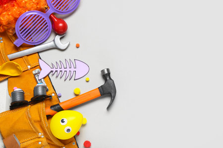 Belt with construction tools and party decor for April Fools Day celebration on gray backgroundの写真素材