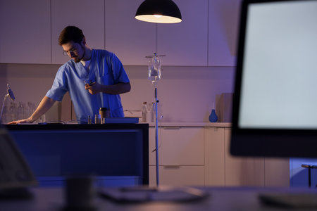 Male nurse with ampules working evening shift in clinicの写真素材