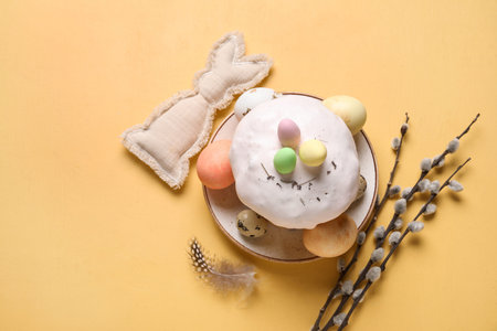 Easter cakes, toy bunny, willow branches and painted eggs on beige background