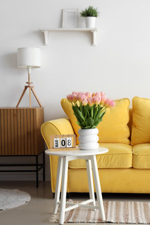 Calendar with date of International Women's Day and tulips on table in light living roomの写真素材
