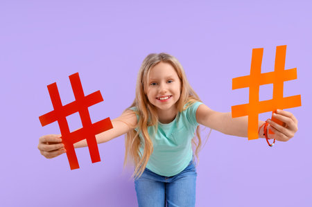 Cute teenage girl with hashtags on lilac backgroundの写真素材