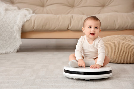 Cute little baby sitting on robot vacuum cleaner at homeの写真素材
