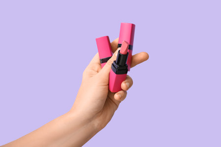 Female hand with different lipsticks on lilac backgroundの写真素材