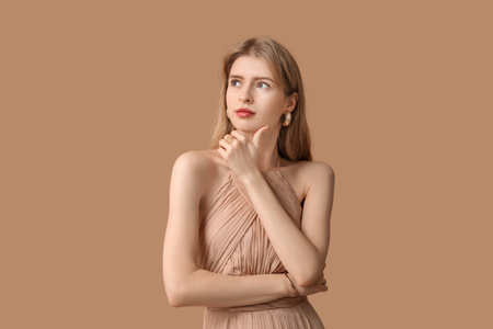 Beautiful young woman with stylish jewelry on brown backgroundの写真素材