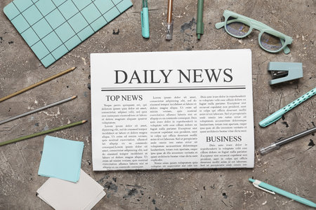 Newspaper with eyeglasses and stationery on gray grunge backgroundの写真素材