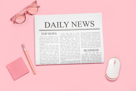 Newspaper with eyeglasses, stickers and computer mouse on pink backgroundの写真素材