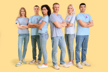 People with pink and lavender awareness ribbons on yellow background. World Cancer Day