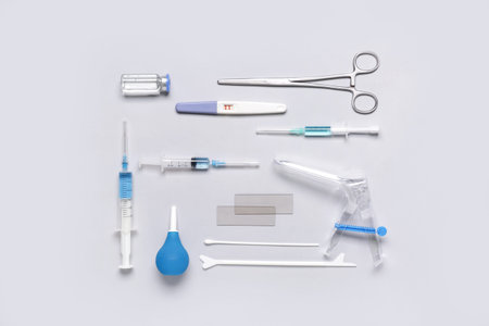 Gynecological speculum with pap smear test tools, syringes and ampule on white background