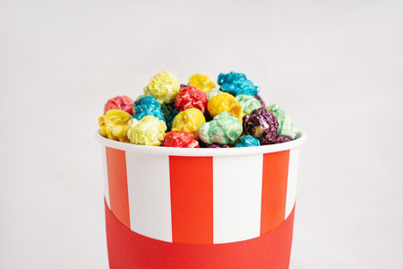 Bucket with sweet colorful popcorn on white background, closeupの写真素材