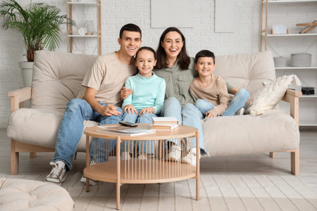 Family watching TV on sofa at home
