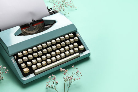 Vintage typewriter and gypsophila on turquoise background. Women's Day conceptの写真素材