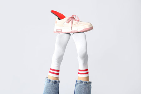 Sneakers with orthopedic insoles on female legs isolated on white background, closeup