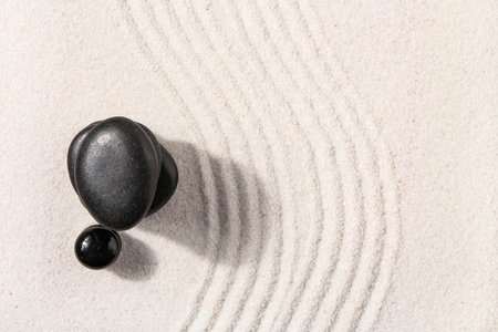 Stones on sand with lines in Japanese rock garden, top view. Zen concept