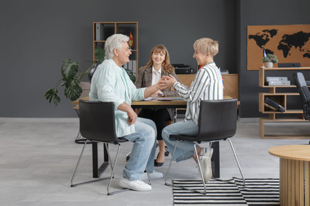 Mature couple holding hands in travel agency