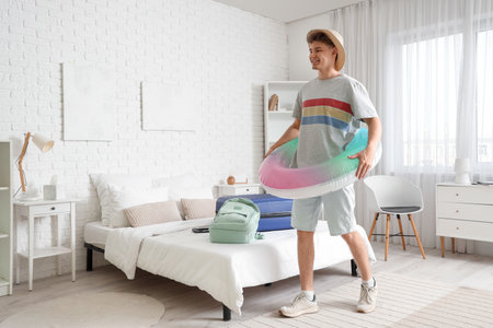 Male tourist with swim ring in hotel roomの写真素材