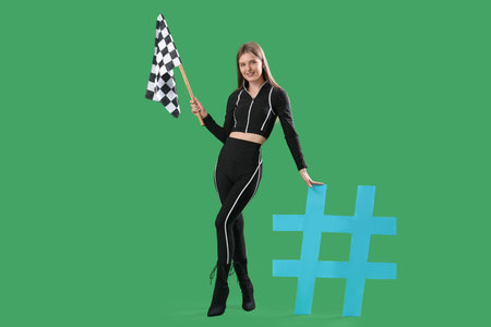 Beautiful grid girl with racing flag and hashtag sign on green backgroundの写真素材