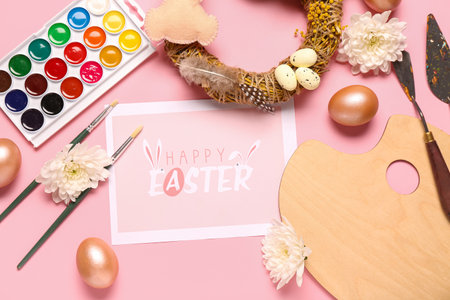 Composition with greeting card, painter supplies and Easter decor on pink backgroundの写真素材