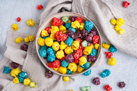 Bowl with sweet colorful popcorn on white backgroundの写真素材