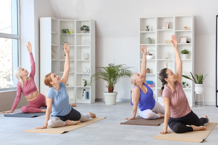 Group of sporty mature women doing yoga in gymの写真素材