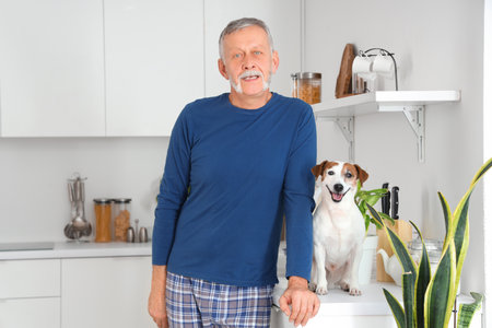 Mature man with cute Jack Russell terrier on counter in kitchenの写真素材