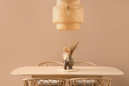 Stylish wooden table and chairs near color wall