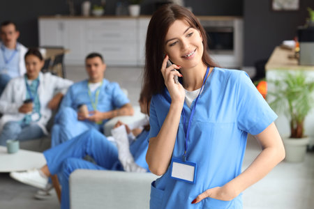 Female doctor talking by mobile phone in hospitalの写真素材